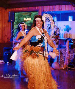A woman in a hula outfit dancing on stage.