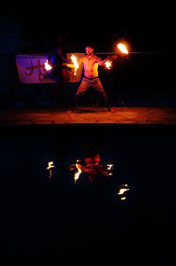 A man holding fire in his hands and performing tricks.