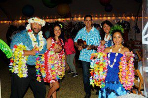 A group of people in hawaiian costumes at night.