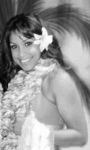 A woman in a white dress and flower lei.