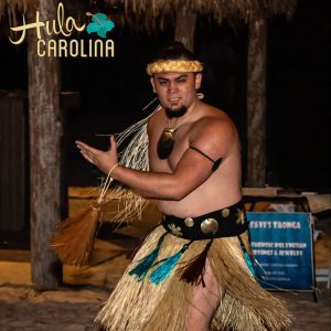 A man in a hula outfit is performing.